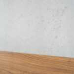 Wand in Betonoptik hinter Bett